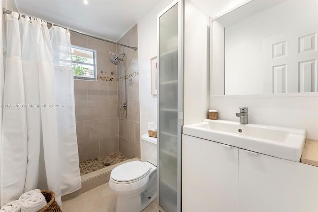 full bathroom featuring tile patterned flooring, a shower stall, toilet, and vanity