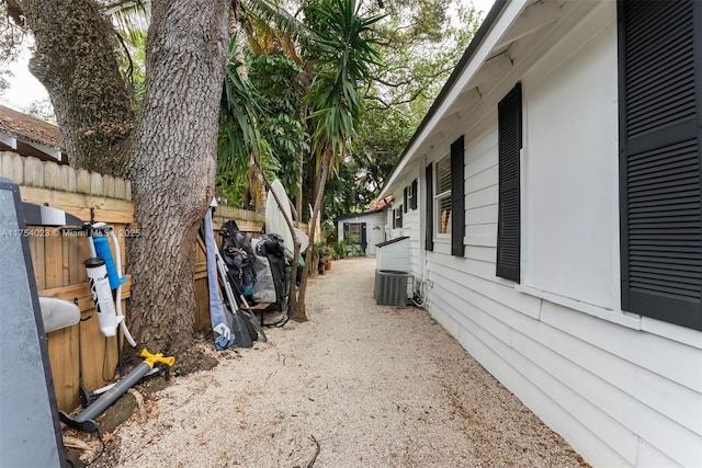 view of side of property with fence and central AC unit