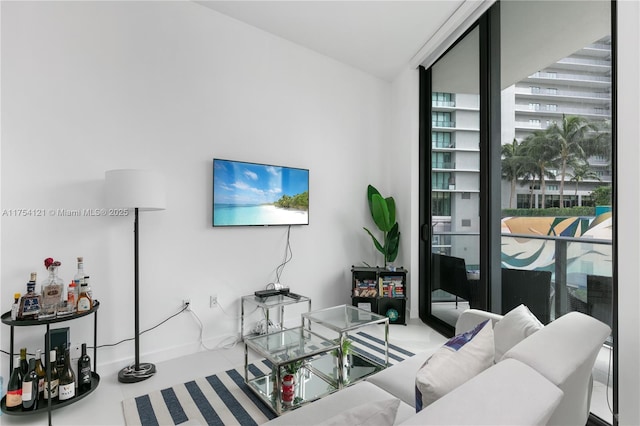 living room featuring a wall of windows and baseboards