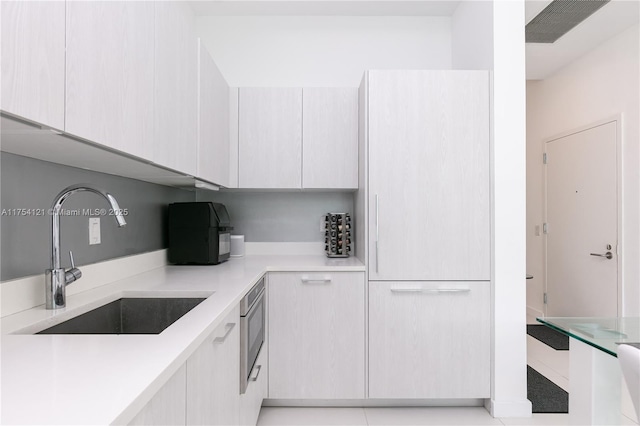 kitchen with modern cabinets, light countertops, and a sink