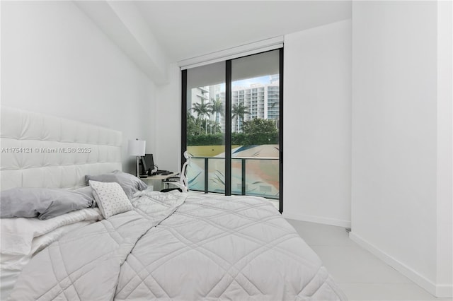 bedroom featuring access to exterior, baseboards, and a wall of windows