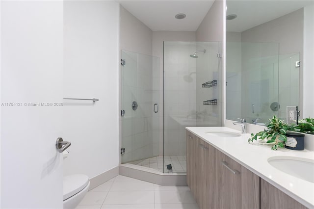 full bath featuring toilet, a stall shower, a sink, and tile patterned floors