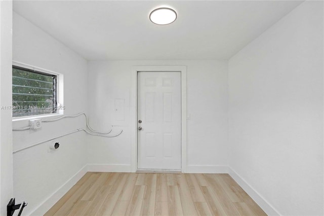 spare room with light wood-type flooring and baseboards