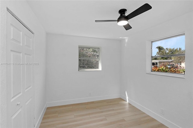 unfurnished room featuring light wood-style flooring, baseboards, and a ceiling fan