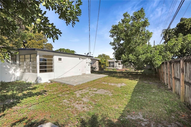 view of yard with a sunroom, a patio area, and a fenced backyard