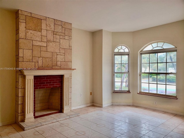 unfurnished living room with baseboards, tile patterned flooring, and a healthy amount of sunlight