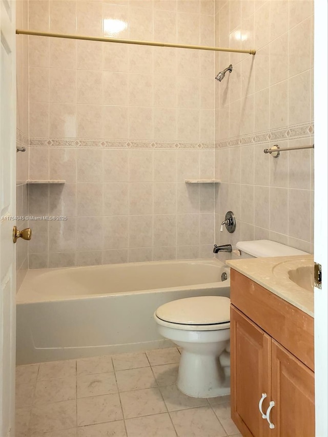 bathroom featuring tile patterned flooring, shower / bathtub combination, toilet, vanity, and tile walls