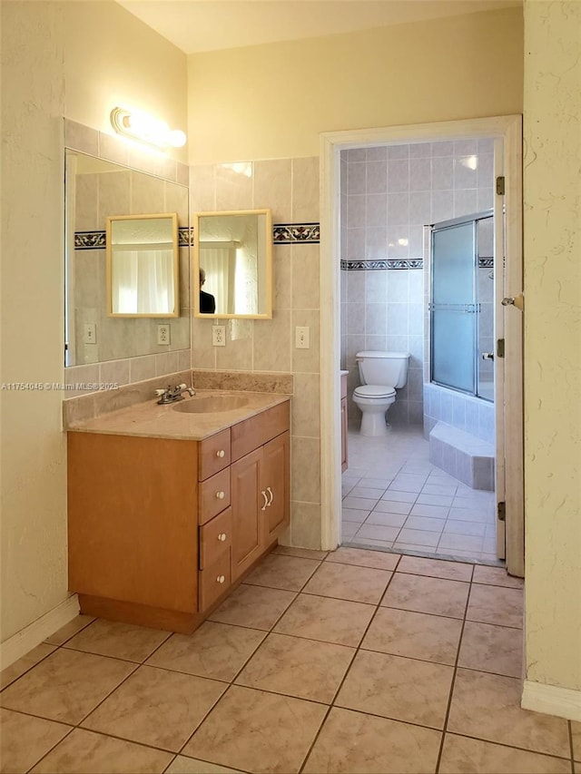full bath with tile patterned floors, a bathing tub, vanity, a shower, and toilet
