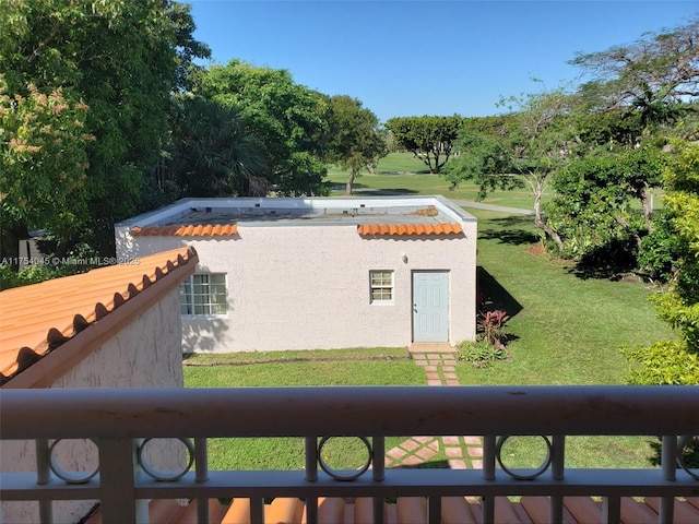 view of home's exterior featuring a tiled roof, a yard, and stucco siding