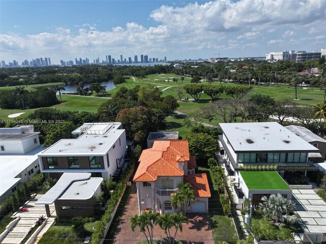 drone / aerial view featuring a water view, view of golf course, and a view of city