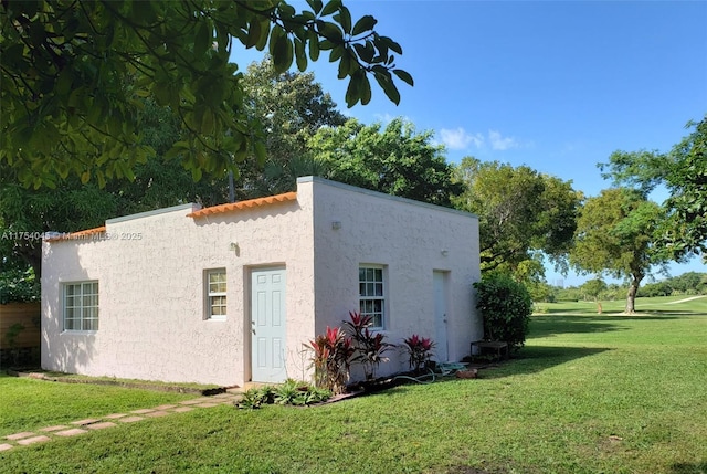 exterior space featuring stucco siding and a yard