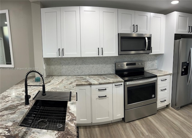 1640 NW 93rd Ave Unit 306, Pembroke Pines, FL 33024 - kitchen with washer / clothes dryer, appliances with stainless steel finishes, a barn door, light stone counters, and baseboards