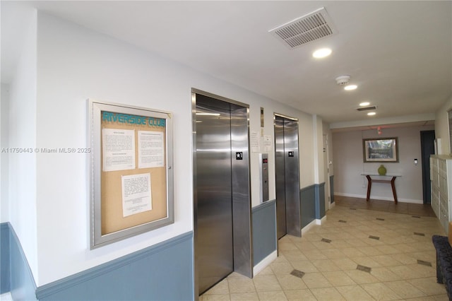 corridor with light tile patterned floors, recessed lighting, visible vents, and elevator