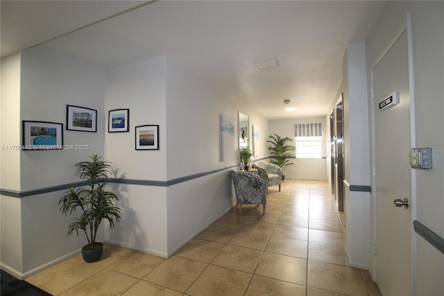 hallway featuring light tile patterned floors and baseboards