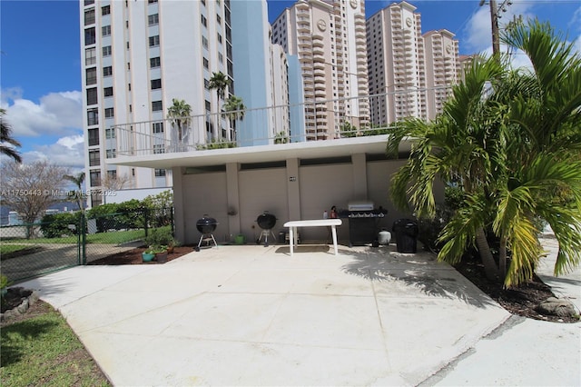 view of patio / terrace with a view of city and fence