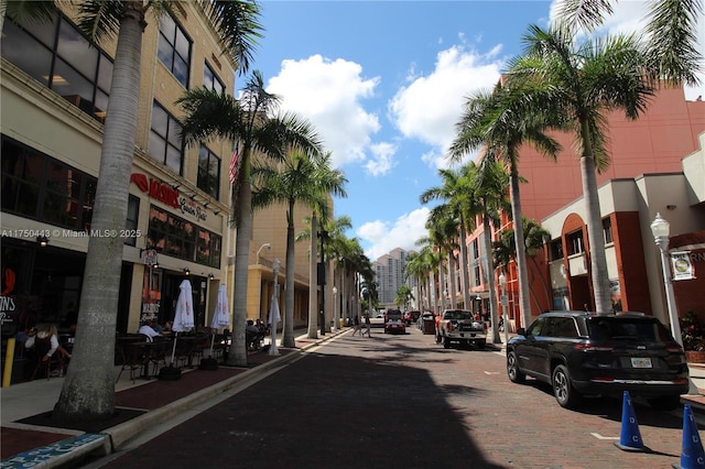 view of road featuring street lighting, curbs, and sidewalks