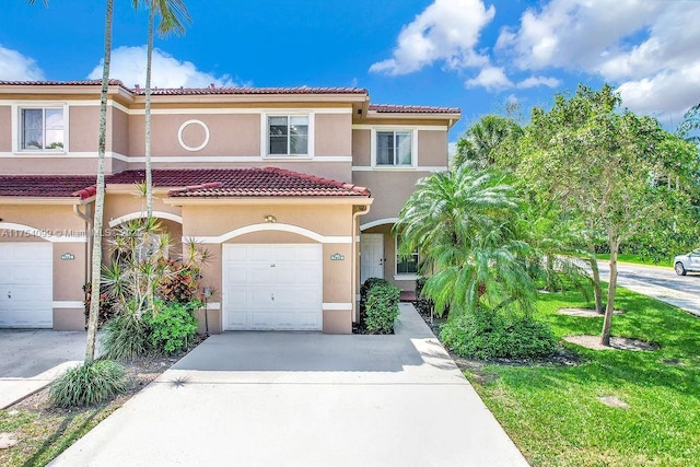 view of front of property featuring driveway, a tiled roof, an attached garage, and stucco siding