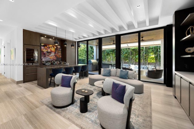 living room with expansive windows, a dry bar, and light wood finished floors