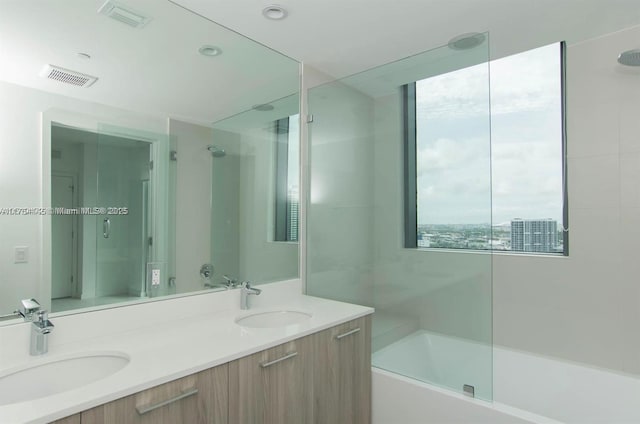 bathroom featuring double vanity, shower / bathing tub combination, a sink, and visible vents