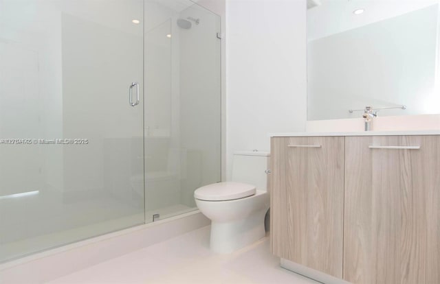 full bathroom featuring a stall shower, vanity, and toilet