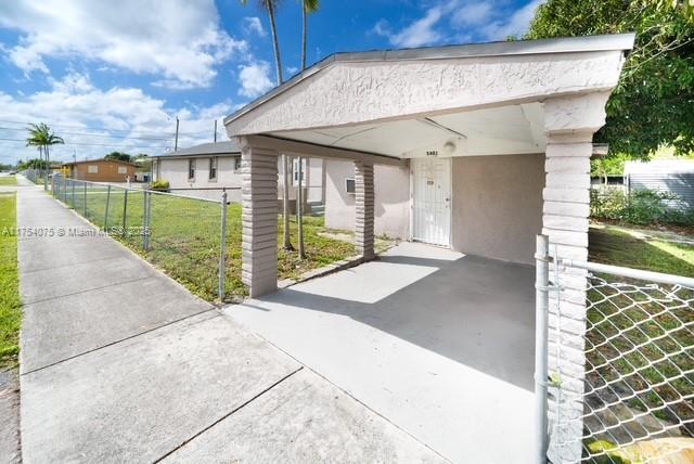 exterior space featuring a lawn, fence, and a gate