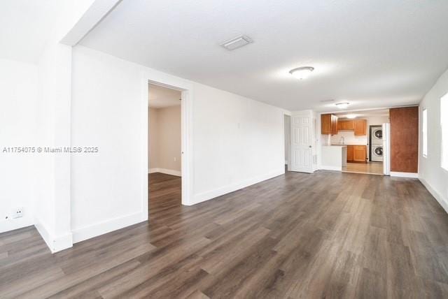 unfurnished living room with baseboards and dark wood-style flooring