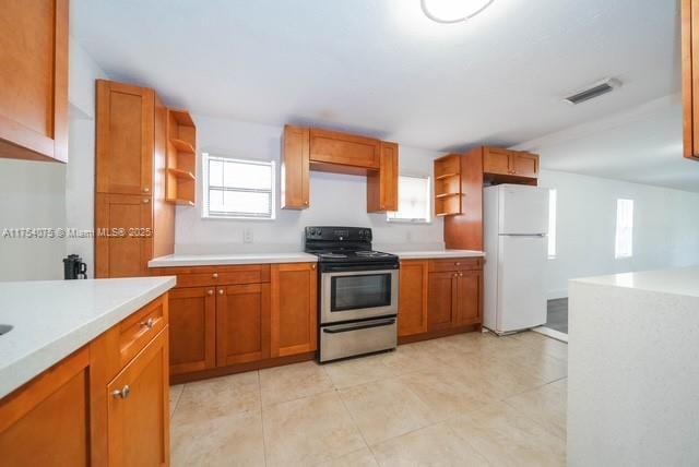 kitchen with visible vents, light countertops, stainless steel electric range, freestanding refrigerator, and open shelves