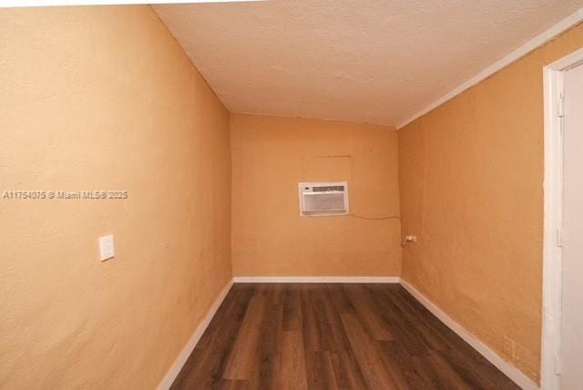 laundry room featuring a wall mounted air conditioner, dark wood finished floors, and baseboards