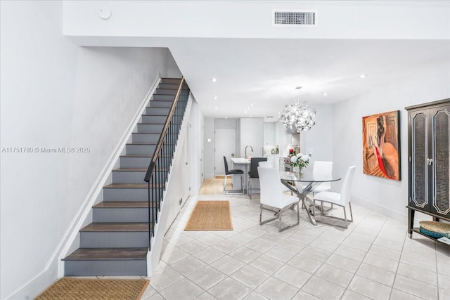 unfurnished dining area with baseboards, visible vents, an inviting chandelier, stairs, and light tile patterned flooring