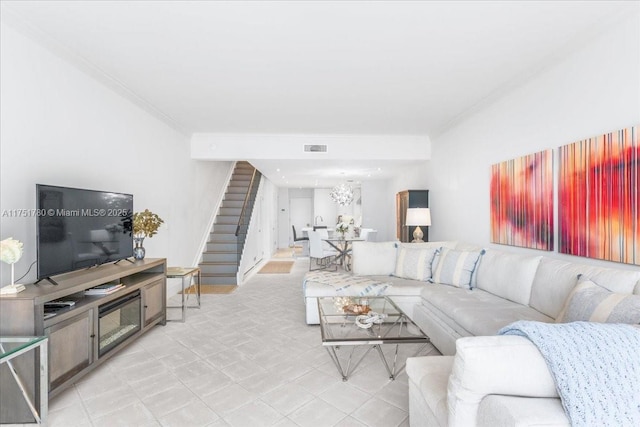 living area featuring visible vents, stairway, and crown molding