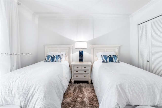 carpeted bedroom featuring ornamental molding and a closet