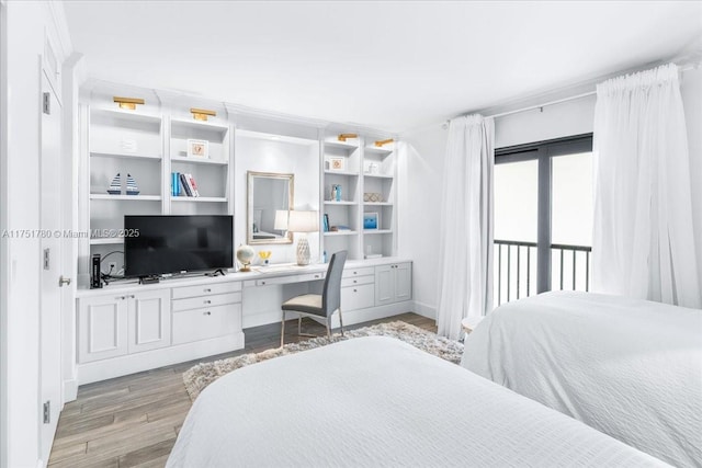 bedroom featuring light wood-style floors, access to exterior, and built in study area