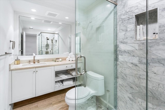 full bath featuring toilet, wood finished floors, vanity, a shower stall, and crown molding