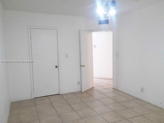 unfurnished bedroom with light tile patterned floors and visible vents