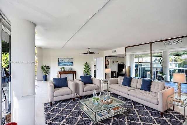 living area with a ceiling fan, visible vents, and tile patterned floors