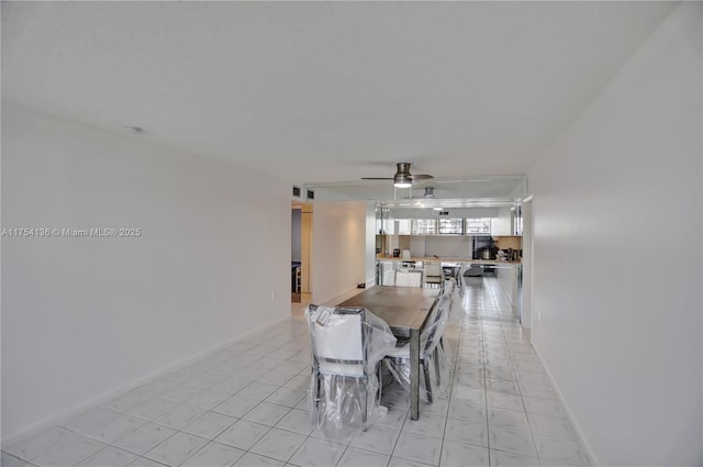 dining space featuring ceiling fan and baseboards