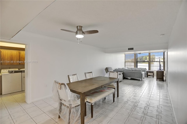 dining area with baseboards, visible vents, a ceiling fan, and washing machine and clothes dryer