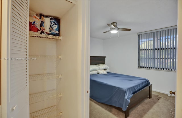 carpeted bedroom featuring baseboards and a ceiling fan