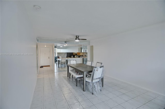 dining space featuring ceiling fan and baseboards