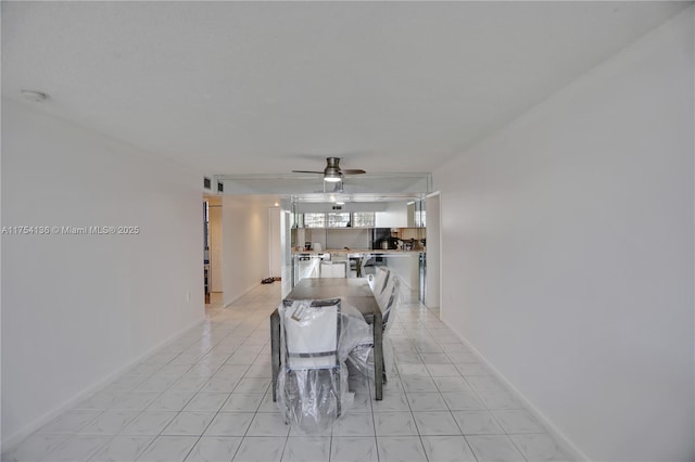 dining area featuring ceiling fan, baseboards, and light tile patterned floors