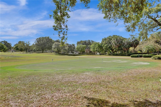 view of home's community with golf course view and a lawn