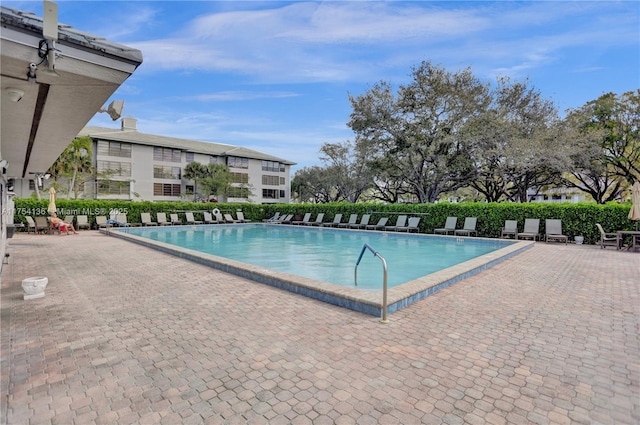 community pool with a patio and fence