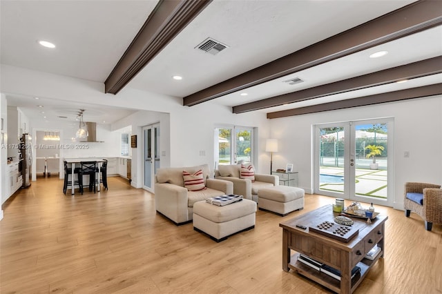 living area featuring visible vents, beamed ceiling, french doors, light wood-style floors, and recessed lighting