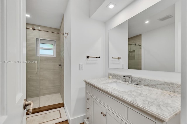 full bathroom featuring baseboards, visible vents, a shower stall, and vanity