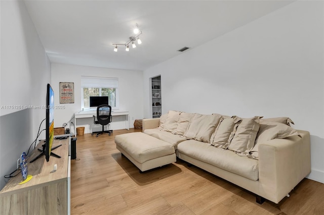 living area with light wood-type flooring and visible vents