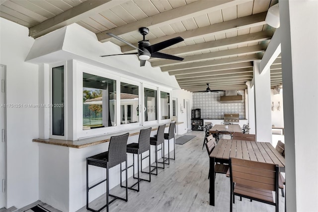 view of patio featuring outdoor dry bar, ceiling fan, outdoor dining area, and grilling area