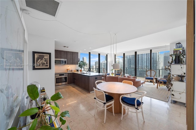 dining room featuring a view of city, visible vents, and a wealth of natural light