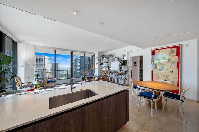 kitchen with open floor plan, light countertops, a sink, and dark brown cabinetry