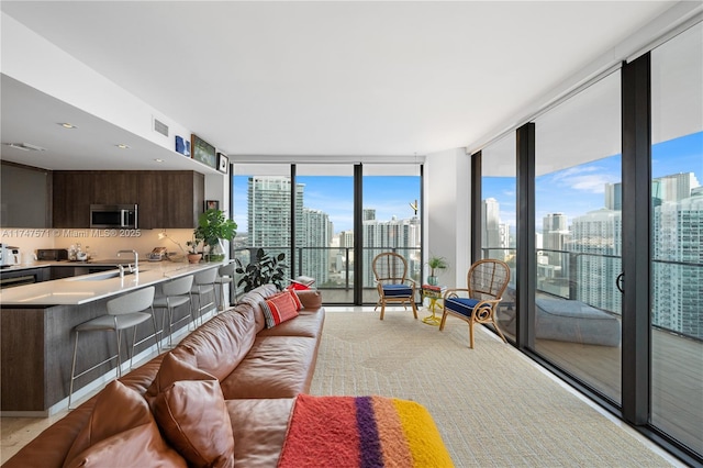 living area featuring a view of city, expansive windows, and visible vents