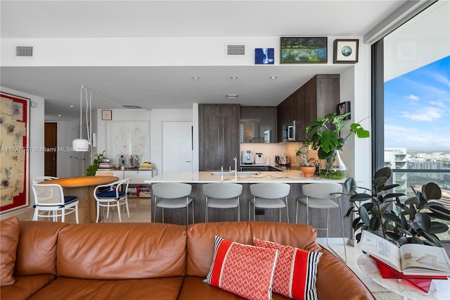 living room featuring a wall of windows and visible vents